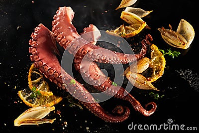 Whole fresh octopus tentacles sizzling on a grill Stock Photo