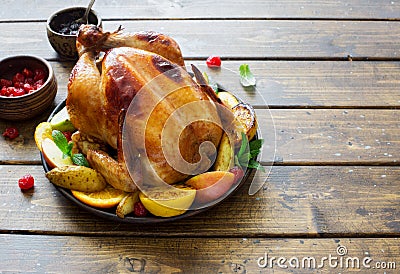 Whole fried chicken with fruits and potatoes close up Stock Photo