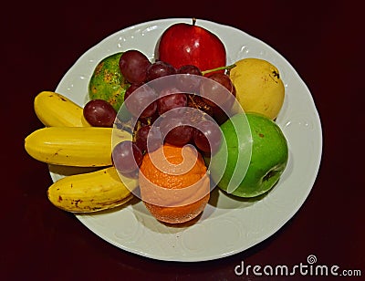 Whole Fruit Platter on White Plate on Wooden Table Stock Photo