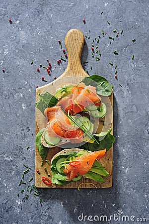 Whole grain bread sandwiches with fresh cucumber, spinach leaves, avocado and smoked salmon Stock Photo