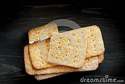 Whole grain cookies, thin crisp bread with spices and herbs on black background. Stock Photo