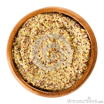 Whole grain Dijon mustard in wooden bowl over white Stock Photo