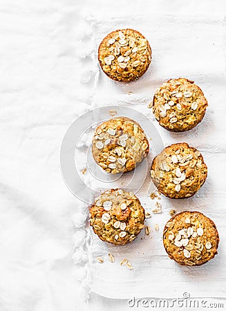 Whole grain mini muffins with dried apricots, oatmeal, apple, carrots and nuts on light background, top view Stock Photo