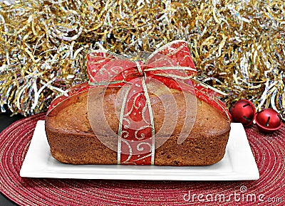 Whole loaf cake wrapped in a red and gold ribbon. Stock Photo