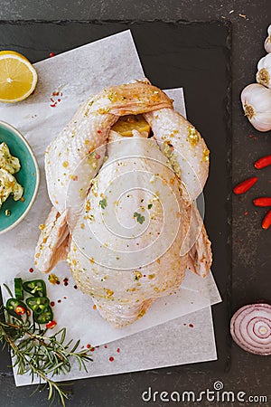 Whole raw chicken seasoned with butter and herbs Stock Photo