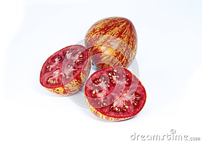 Whole tomato and a halves cut tomatoes on a white background. Ripe motley tomatoes. Stock Photo