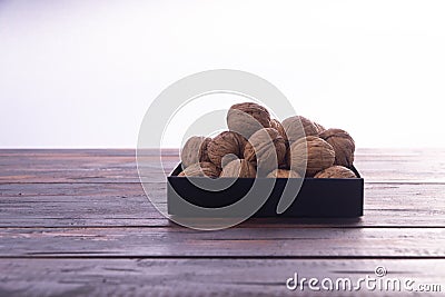 Whole walnuts on wooden table, side view on white background. Healthy nuts and seeds composition. Stock Photo