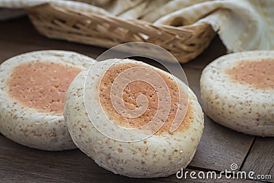 Whole wheat english muffins on wooden table Stock Photo