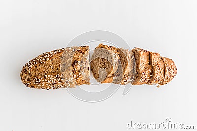 Wholegrain sliced freshly baked bread with flax and sesame seeds on white background. Top view Stock Photo