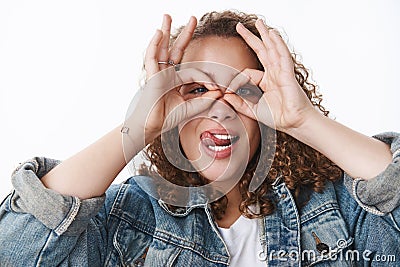 Why so serious. Attractive funny cute silly curly-haired chubby girl fool around making faces stick tongue hold circles Stock Photo