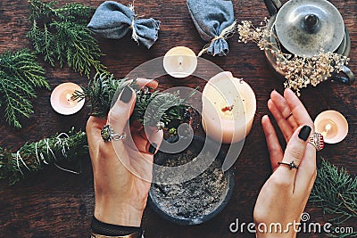 Wiccan witch holding cedar cleansing stick to cleanse the energy at her altar Stock Photo