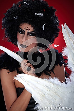 Wicked woman pulling angel feathers Stock Photo