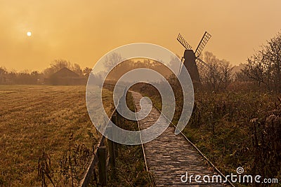 Wicken Fen windmill in early morning mist Stock Photo