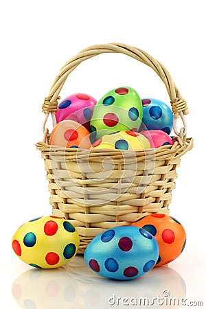 Wicker basket filled with colorful easter eggs Stock Photo