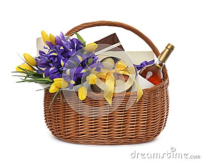 Wicker basket with gift, bouquet and wine on white background Stock Photo