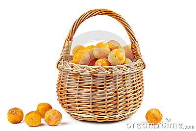 Wicker basket with half-dried yellow cherry plums isolated on the white Stock Photo