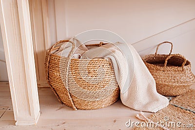 Wicker basket made of recycled materials with beige towel inside. smart storage. reasonable consumption of materials, monochrome Stock Photo