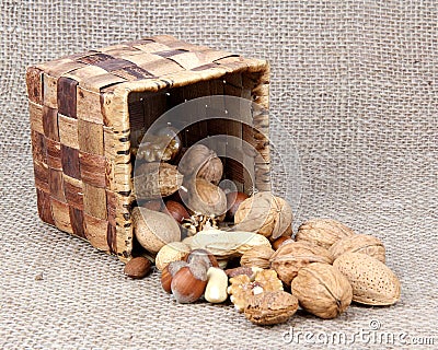 Wicker basket and nuts on canvas Stock Photo