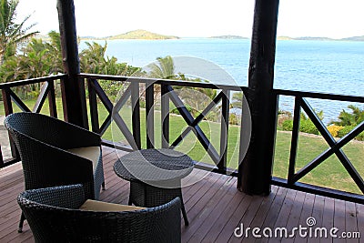 Wicker chairs and table on balcony overlooking gorgeous seascape Stock Photo