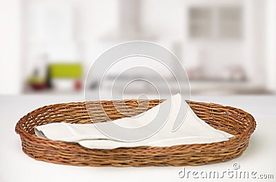 Wicker oval basket with a cotton beige napkin inside on a white table Stock Photo