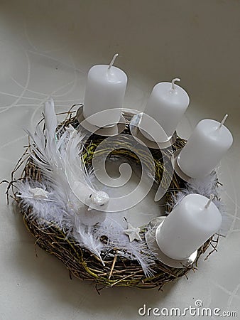 Wicker-work advent crown with four white candles, feathers, star and dove Stock Photo