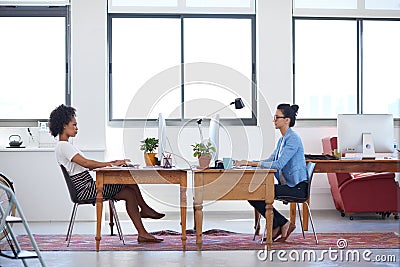 Creative space for contemporary business. Wide angle image of two female creative professionals in an open plan office Stock Photo