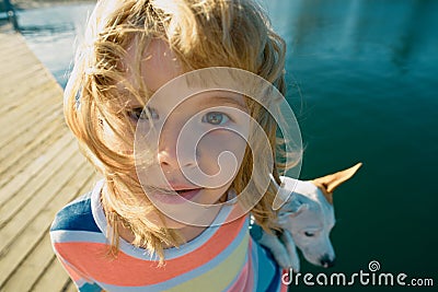 Wide angle kids face. Child lovingly embraces his pet dog. Stock Photo