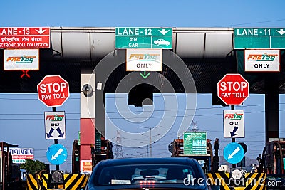 wide angle shot of toll booth in india with the Fast tag FASTag signs on all lanes showing the mandatory new RFID based Editorial Stock Photo