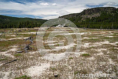 Wide angle vast shot of Biscuit Basin thermal area with hot springs. Boardwalks with tourists in far distance Stock Photo