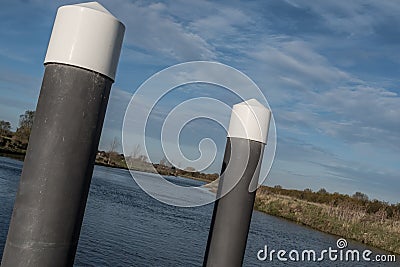 Wide angle view of a canal boat mooring platform seen within a wide expanse of water. Stock Photo