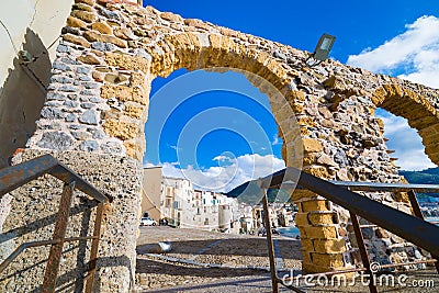 Wide angle view of Cefalu town through stone arch gate, Sicily, Italy Stock Photo