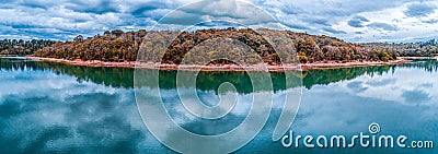 Panorama of trees growing on lakeshore with scenic clouds reflections. Stock Photo