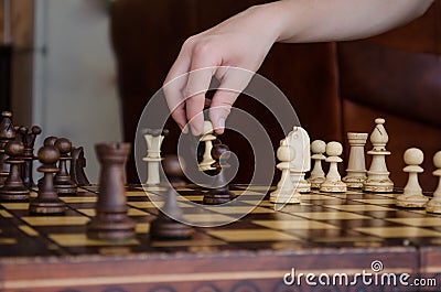 Wide cropped image of a human hand moving a chess piece of a light pawn Stock Photo