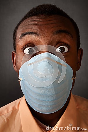 Wide-eyed man in surgical mask Stock Photo