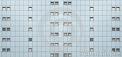 Wide full frame facade of a modern building with geometric metallic cladding and lines of repeating pattern windows Stock Photo