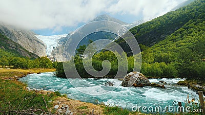 Wide lens shot: Briksdal glacier with a mountain river in the foreground. The amazing nature of Norway Stock Photo