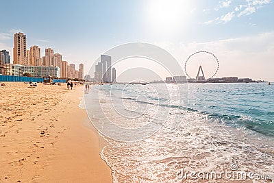 Wide panorama of Persian Gulf with famous Ferris wheel Dubai Eye and numerous skyscrapers with hotels and residences and sandy Stock Photo