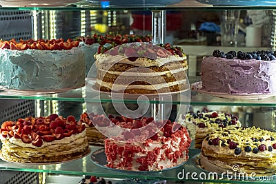 A wide range of cakes with berries and nuts in the pastry shop Stock Photo