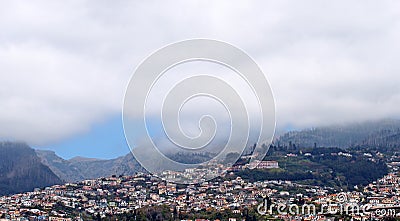Wide scenic panoramic aerial cityscape of the city of funchal in Madeira with buildings of the city in front of mountains with Stock Photo