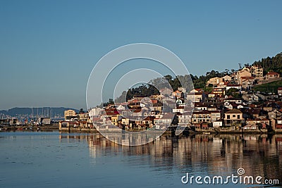 Wide shot of a city full of houses on a hill by the shore on a cool day Stock Photo