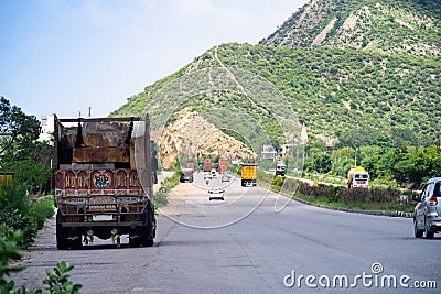 Wide shot of indian highway with trucks parked on side of road, cars, bikes, motorcycle and more on a wide asphalt road Editorial Stock Photo