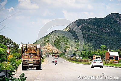 Wide shot of indian highway with trucks parked on side of road, cars, bikes, motorcycle and more on a wide asphalt road Editorial Stock Photo