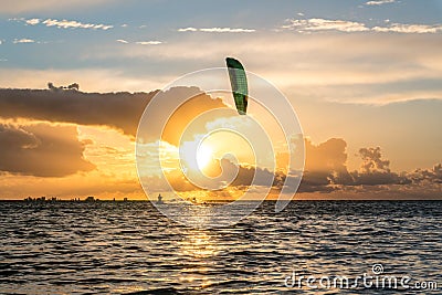 Wide shot of kitesurfer riding in yellow sunset conditions at the Greifswalder Bodden near the baltic sea Stock Photo