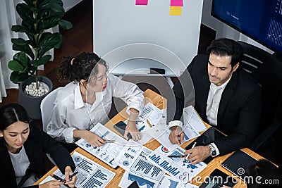 Wide top view diverse analyst team analyzing financial data. Meticulous Stock Photo