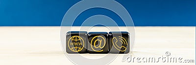 Wide view of customer service image with black dices with gold contact information and location icons on them Stock Photo