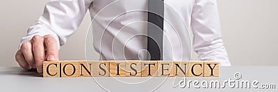 Wide view image of a businessman assembling word Consistency Stock Photo