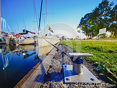Wide view on metal bollard or hook on a quay where moored sailboats Stock Photo