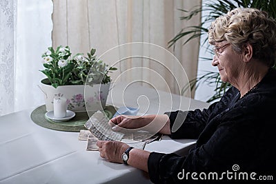 Widow looking over memorabilia Stock Photo