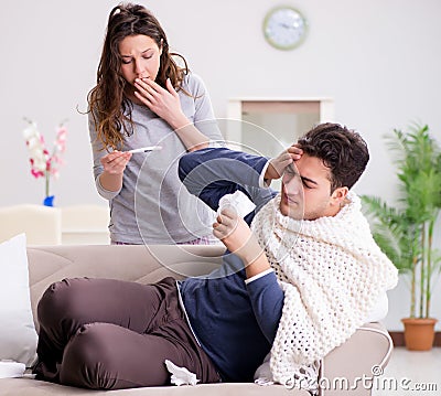 Wife caring for sick husband at home Stock Photo