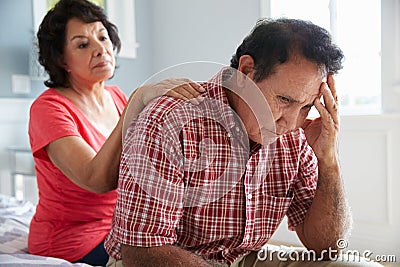 Wife Comforting Senior Husband Suffering With Dementia Stock Photo